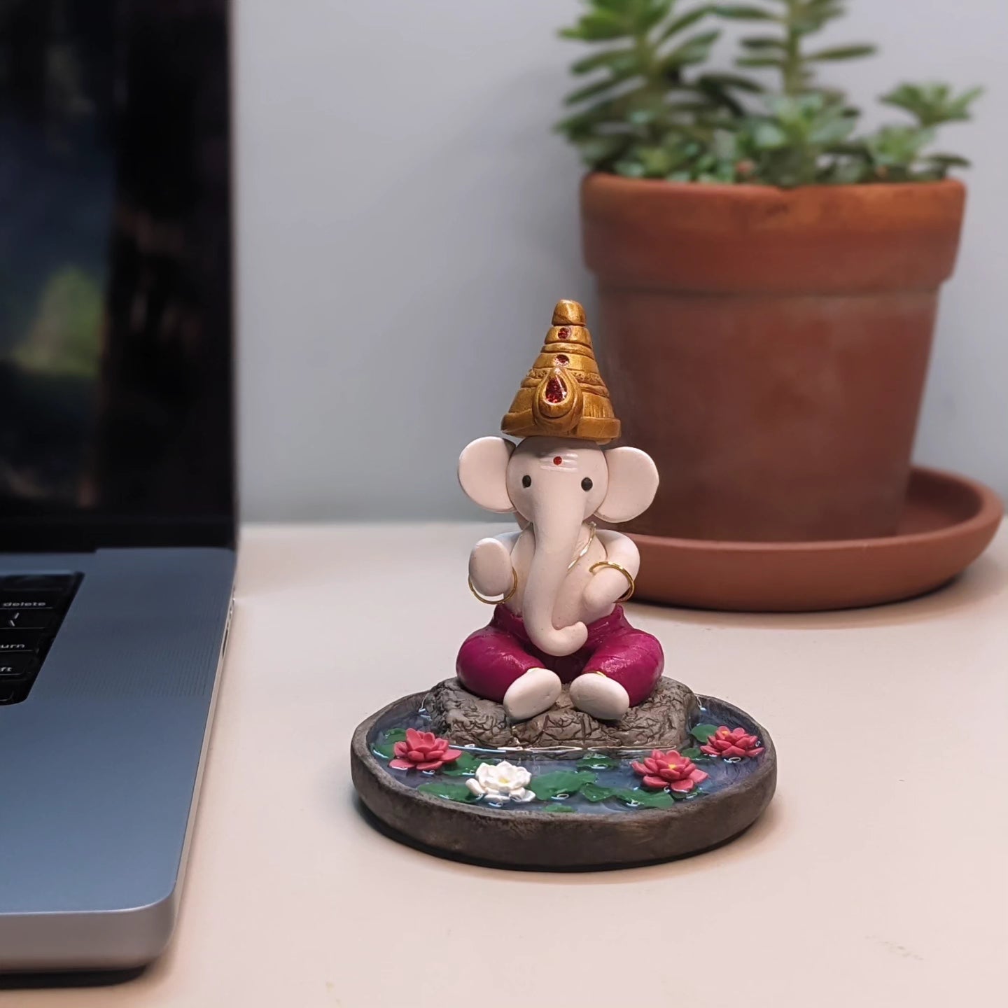 Miniature Ganesha seated in lotus pond