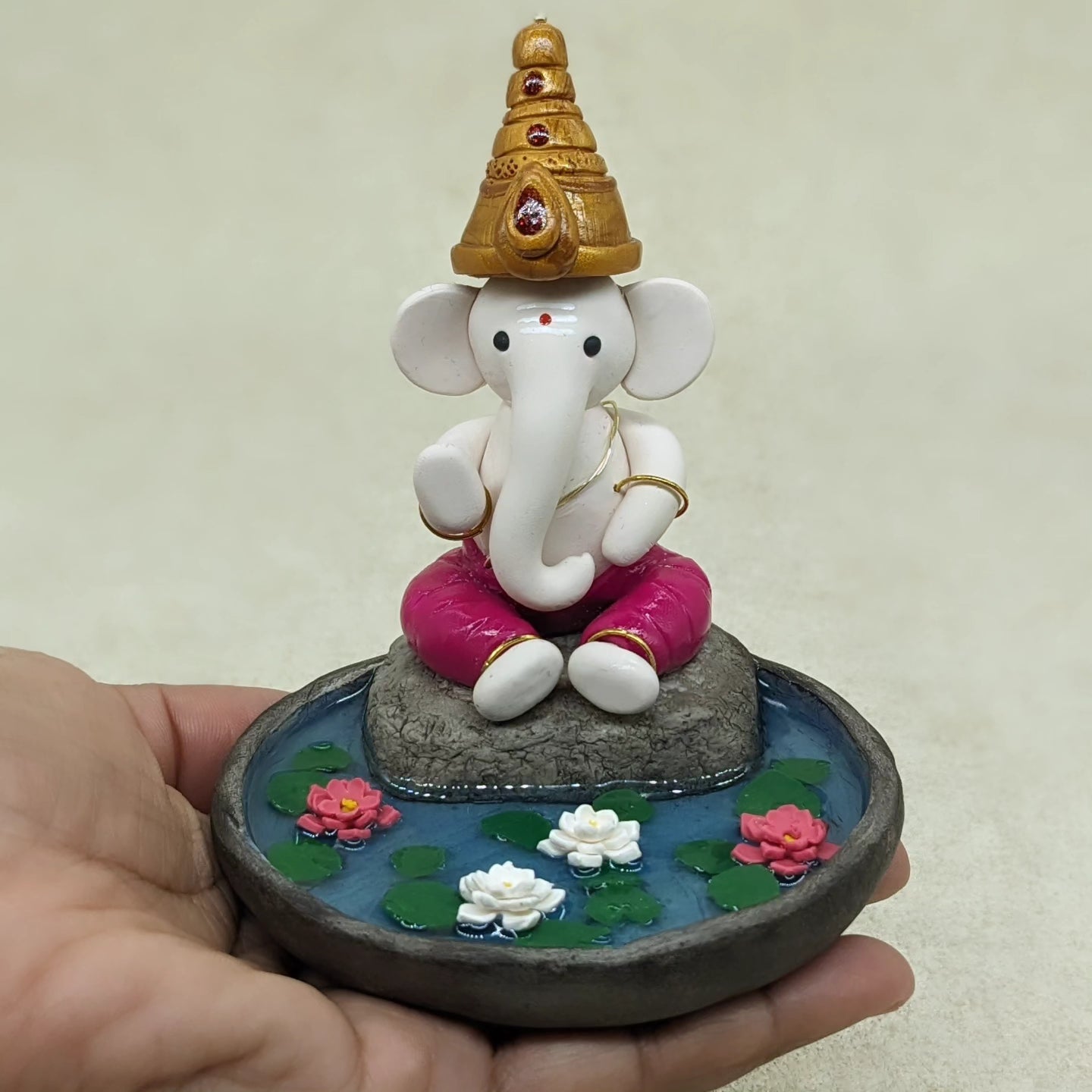 Miniature Ganesha seated in lotus pond